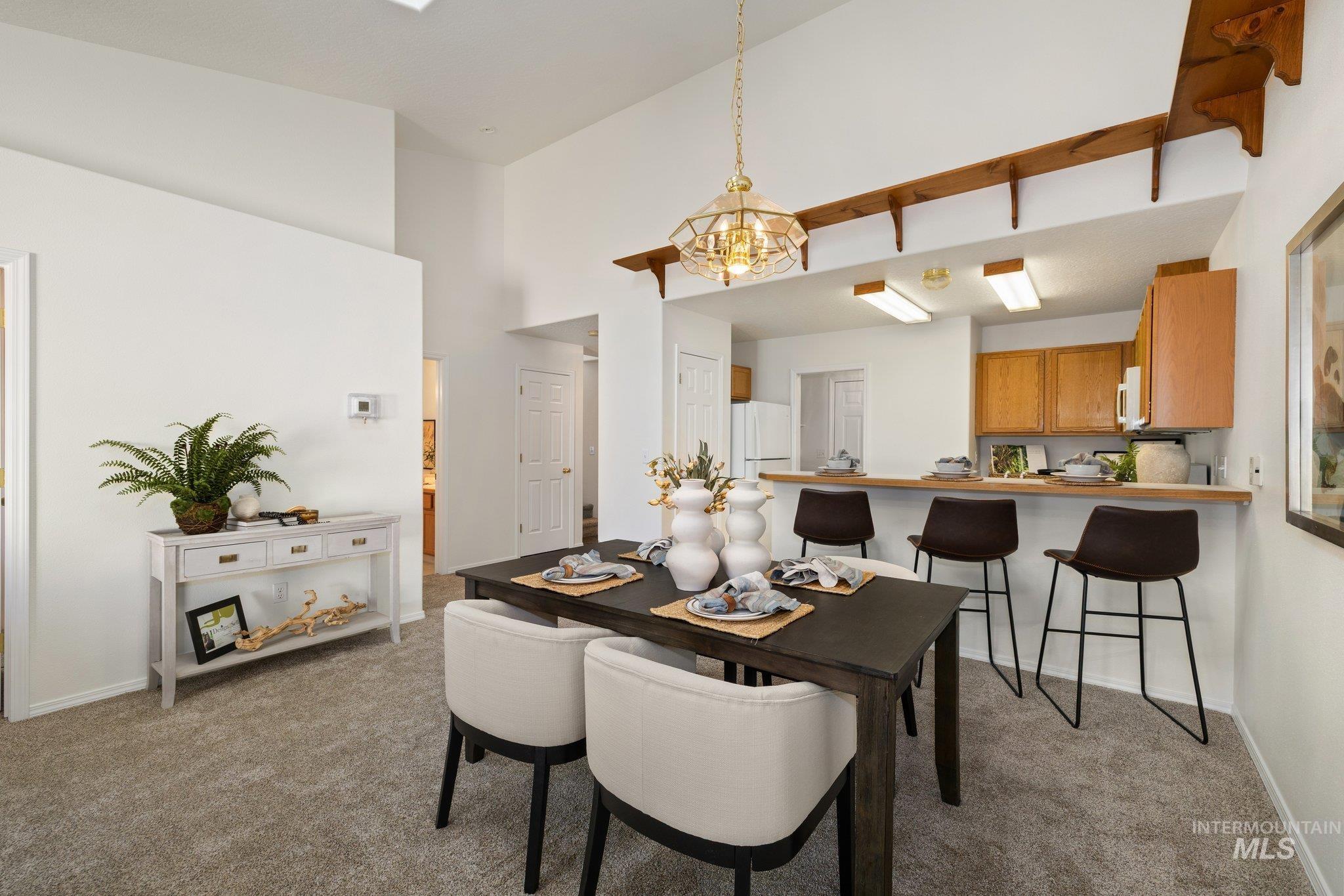 2900 South Ladera Place Boise, ID 83705 - Photo 3 of 31 Dining area with light colored carpet, a towering ceiling, and a chandelier