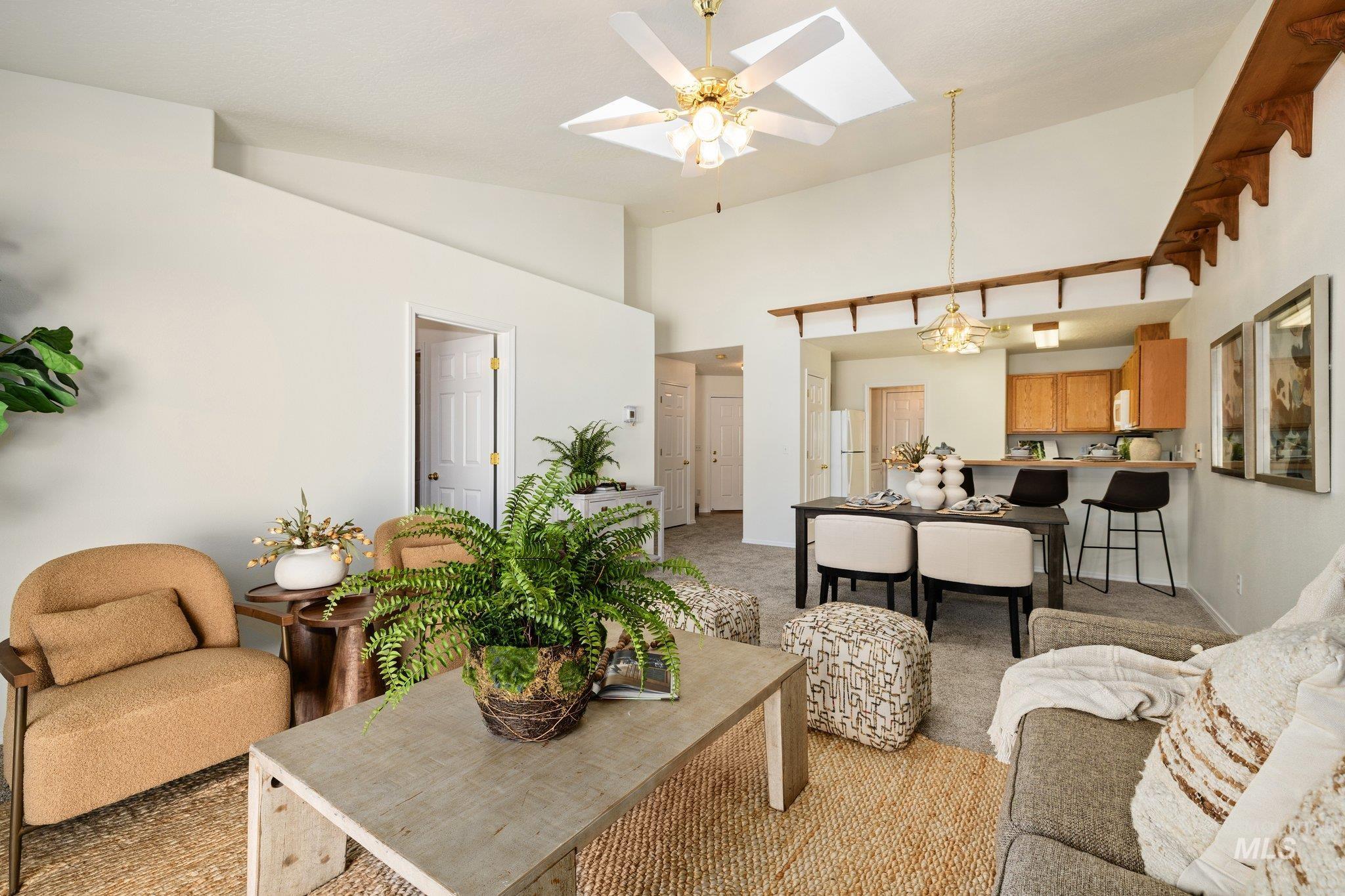 2900 South Ladera Place Boise, ID 83705 - Photo 4 of 31 Living area with a skylight, light carpet, high vaulted ceiling, ceiling fan, and a chandelier