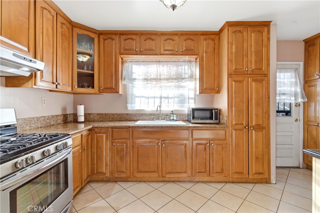 10731 Wright Road South Gate, CA 90280 - Photo 12 of 35 a kitchen with stainless steel appliances granite countertop a stove a sink and a refrigerator
