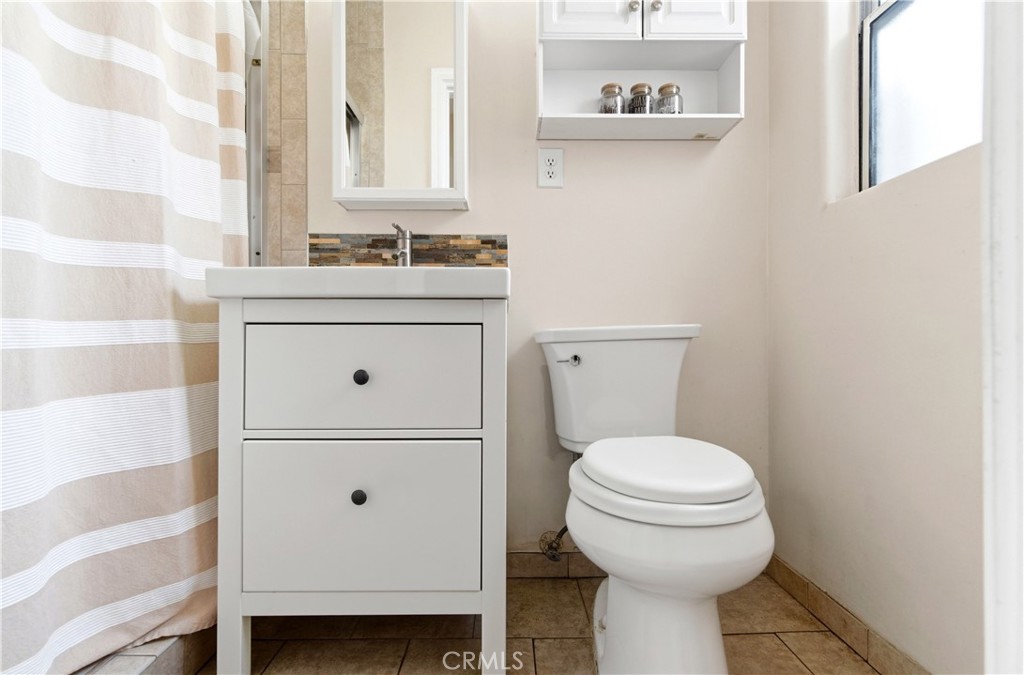 10731 Wright Road South Gate, CA 90280 - Photo 22 of 35 a bathroom with a sink a toilet and a mirror