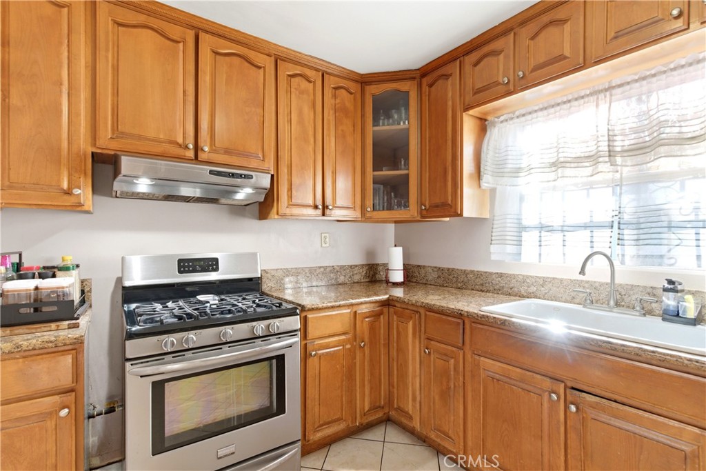 10731 Wright Road South Gate, CA 90280 - Photo 9 of 35 a kitchen with stainless steel appliances granite countertop a sink stove and cabinets