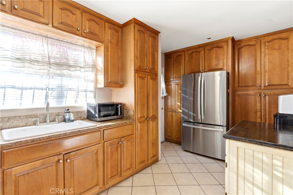 10731 Wright Road South Gate, CA 90280 - Photo 10 of 35 a kitchen with stainless steel appliances a refrigerator sink and cabinets