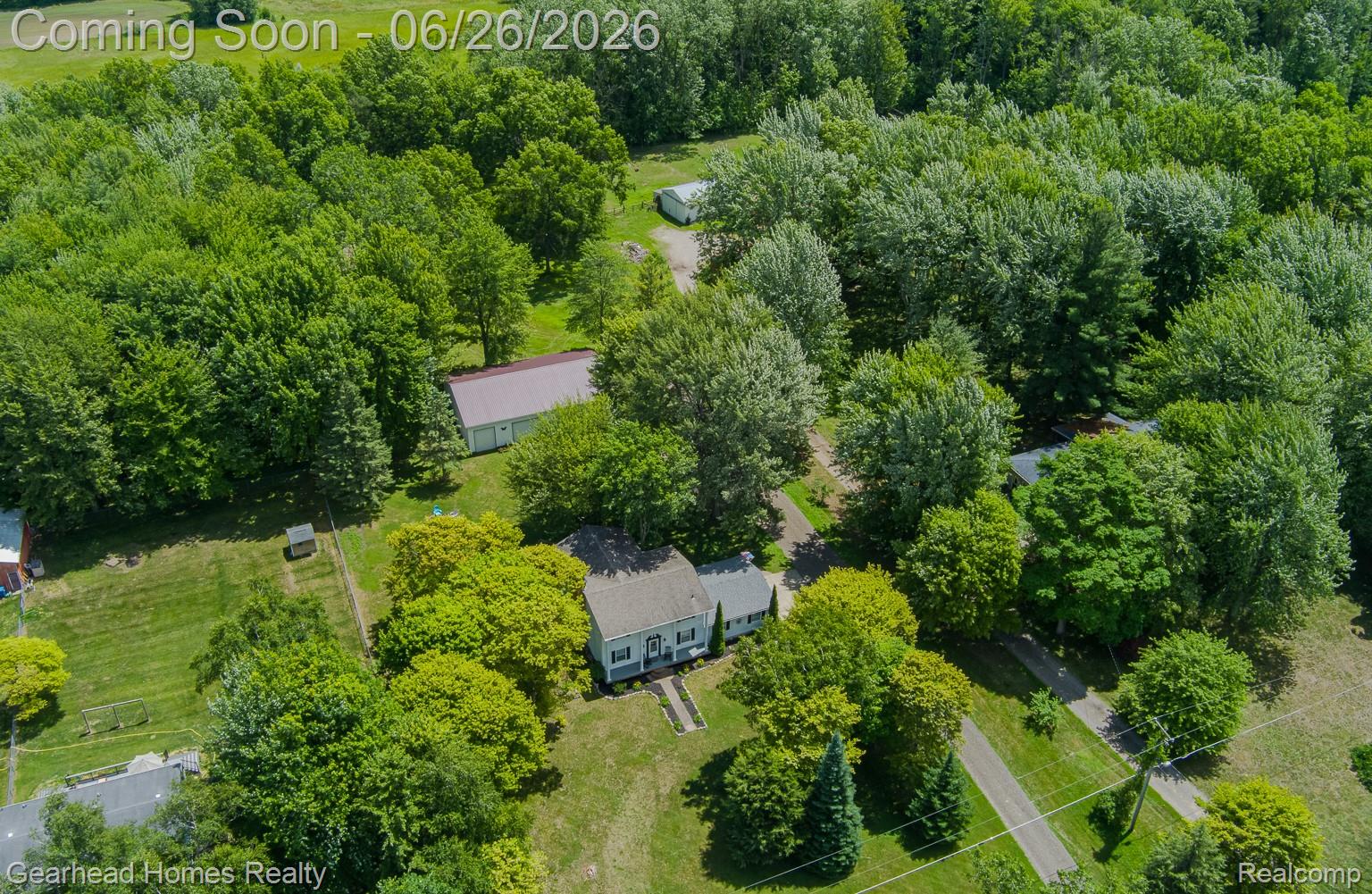 12364 Morrish Road Clio, MI 48420 - Photo 75 of 81 Expansive lot featuring mature trees, a main residence with a light-colored roof, and a separate outbuilding with a red roof