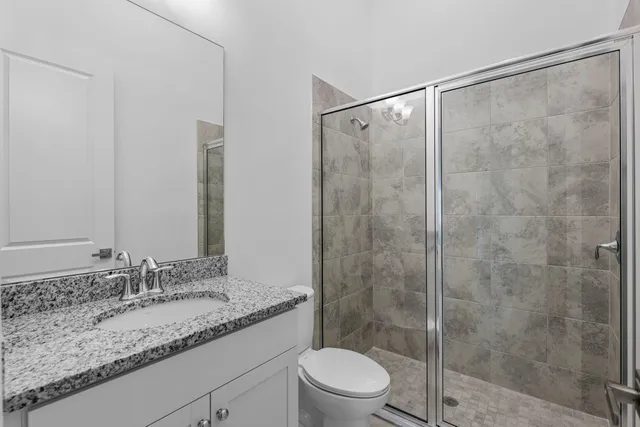 a bathroom with a granite countertop sink toilet and shower