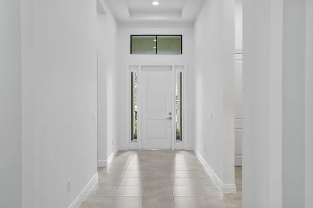 a view of a hallway with wooden floor and a bathroom