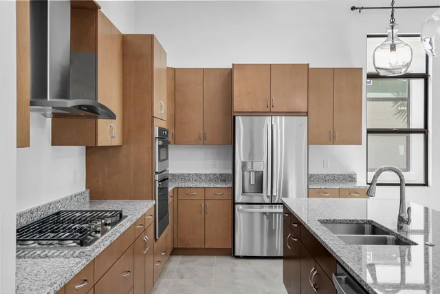 a kitchen with granite countertop a refrigerator and a sink