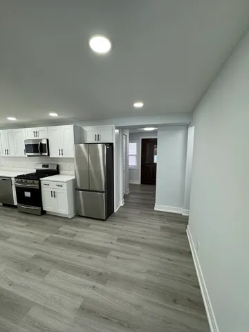 a kitchen with stainless steel appliances granite countertop a refrigerator and a stove