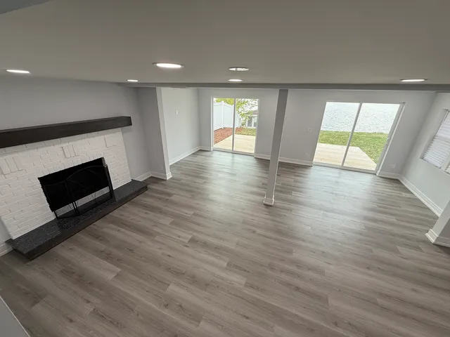 an empty room with wooden floor and fireplace