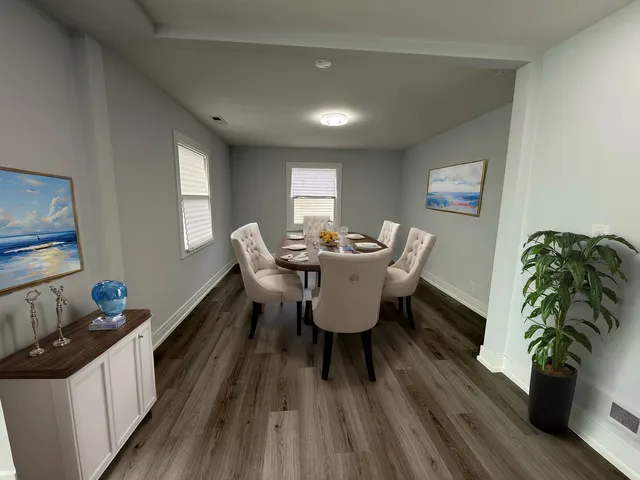 a dining room with furniture potted plants and wooden floor