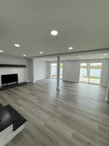 an empty room with wooden floor and fireplace