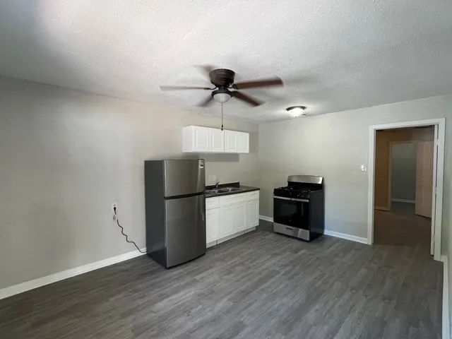 a kitchen with stainless steel appliances a refrigerator and a stove top oven