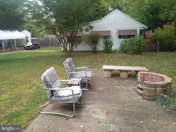 a view of a patio with table and chairs and a big yard