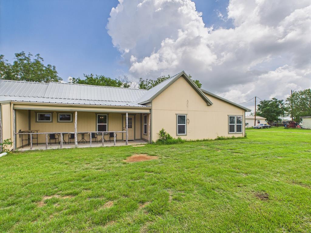 a view of a house with a yard and sitting area