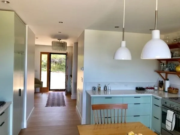 a kitchen with stainless steel appliances a sink a wooden floor and a large window