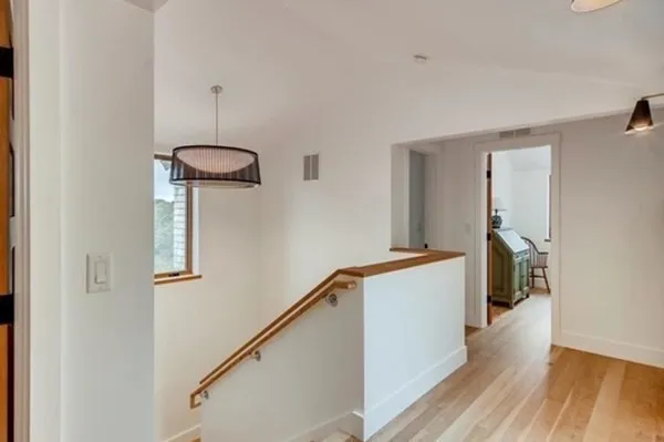 a hallway with stairs and wooden floor