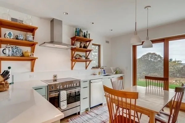 a kitchen with stainless steel appliances granite countertop a stove a sink a dining table and chairs