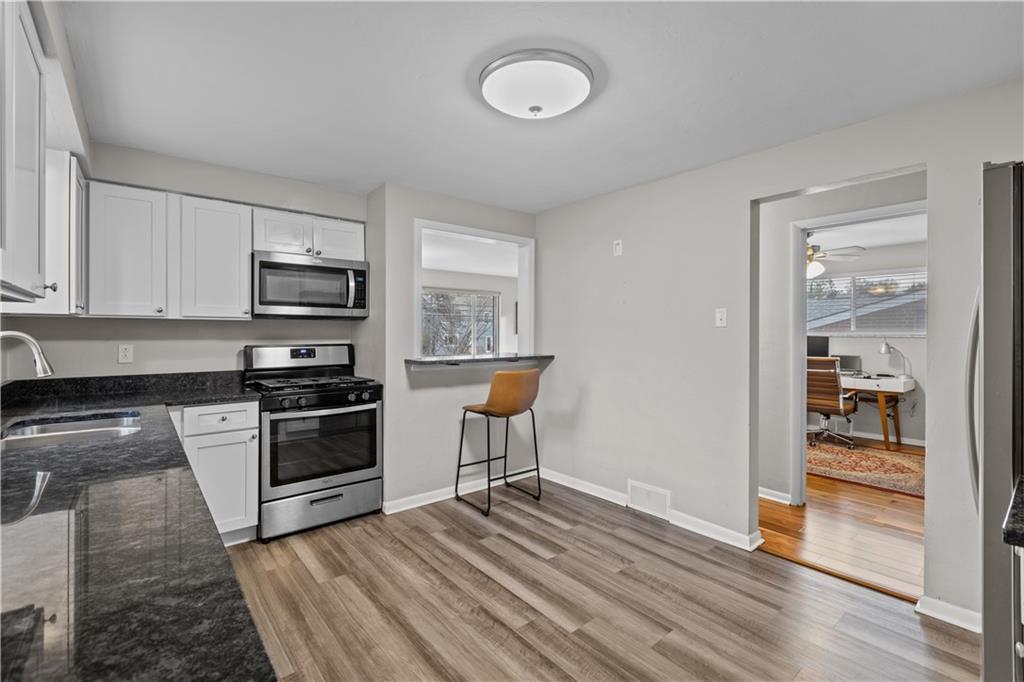 3407 Brighton Road Pittsburgh, PA 15212 - Photo 13 of 27 a kitchen with granite countertop a stove and a wooden floors