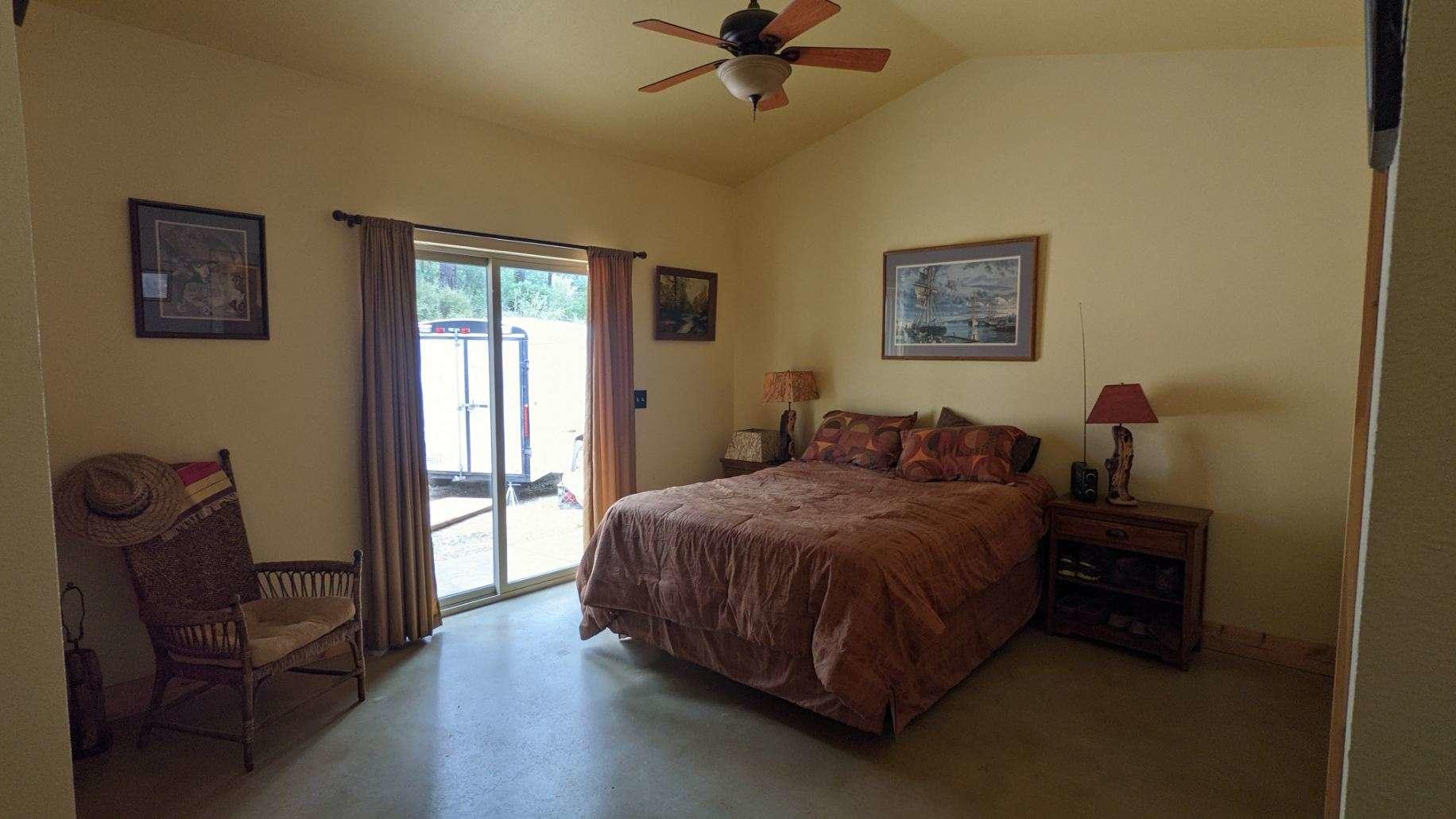 27203 Donkey Mine Road Oak Run, CA 96069 - Photo 8 of 22 a spacious bedroom with a bed and a chair