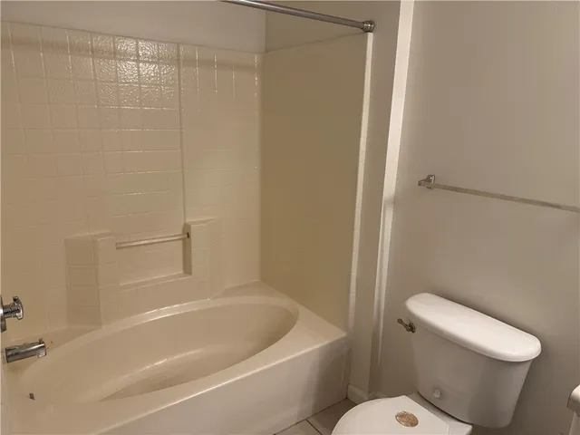 a white toilet sitting next to a bath tub
