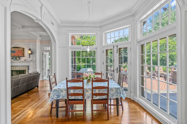 a dining room with furniture large windows and wooden floor