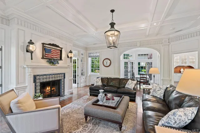 a living room with furniture a fireplace and a chandelier