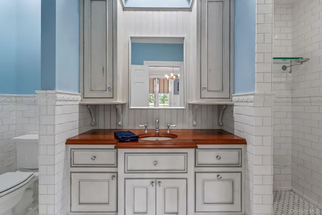 a kitchen with white cabinets and a stove with wooden floor