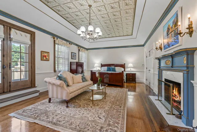 a living room with furniture a fireplace and a chandelier