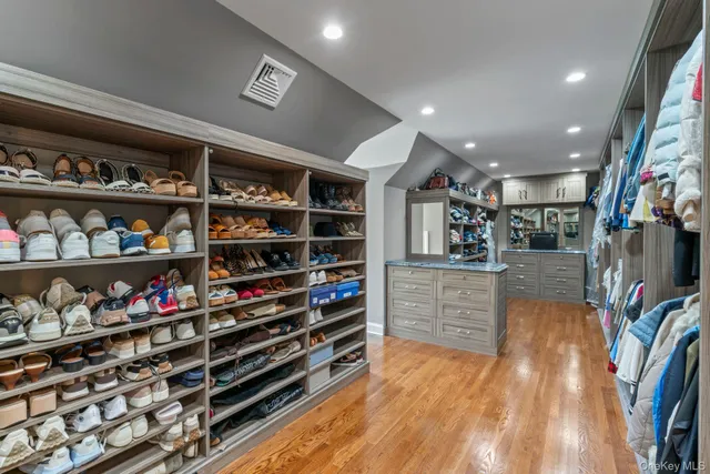 a view of walk in closet with clothes and shoes