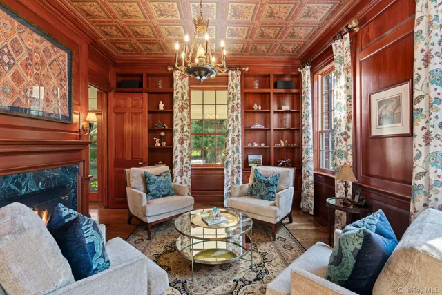a living room with furniture a chandelier and a fireplace