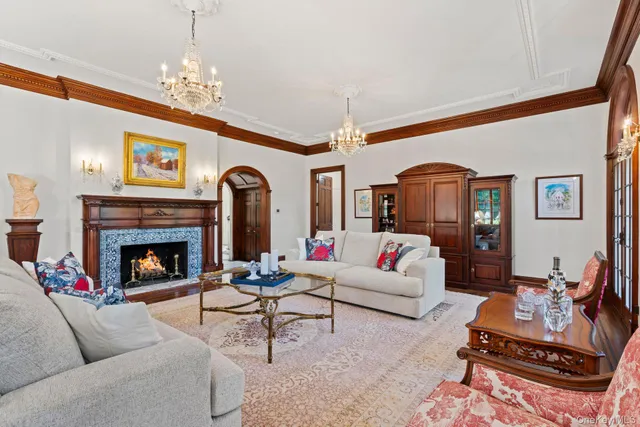 a living room with furniture a chandelier and a fireplace