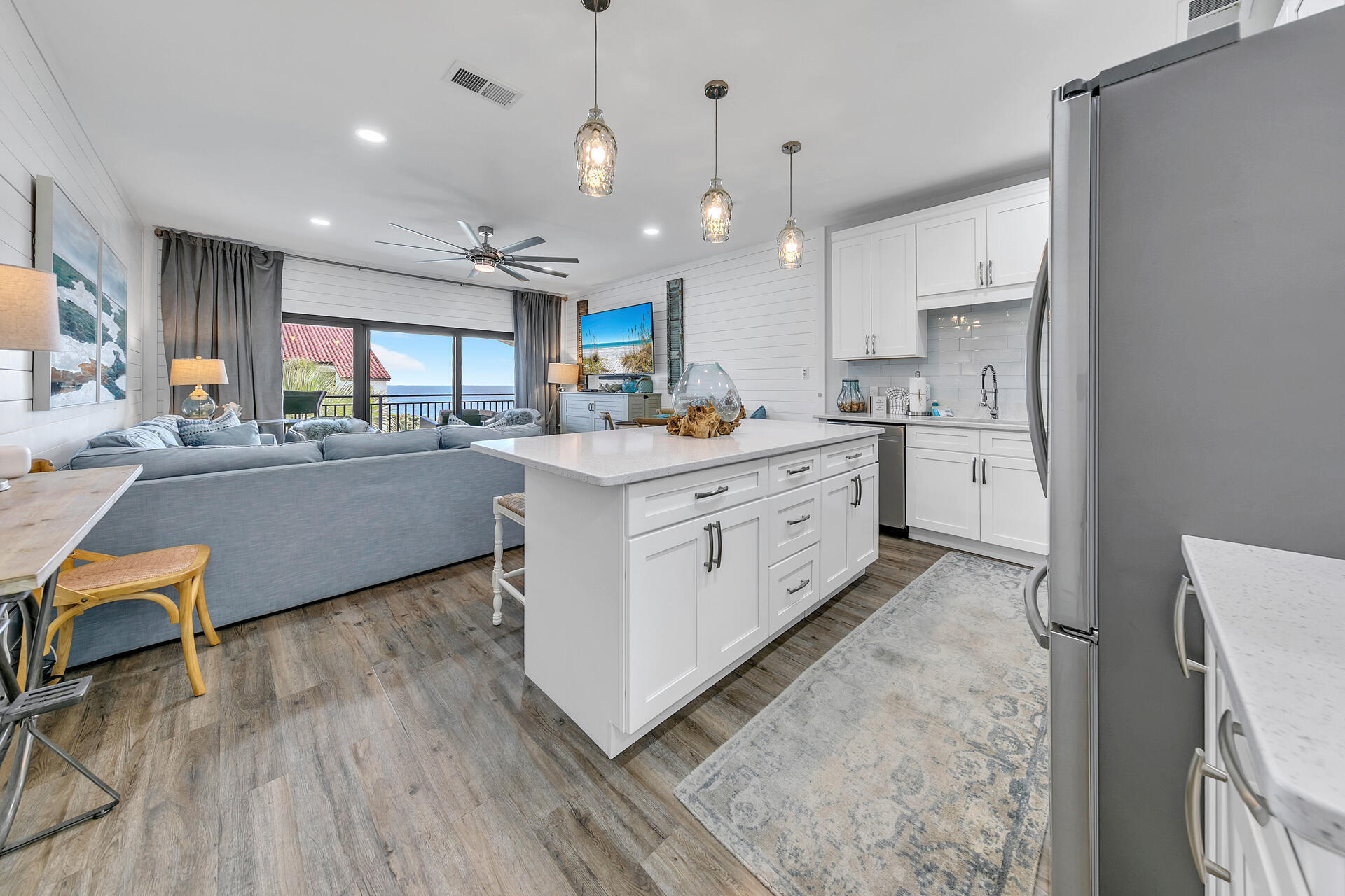 3604 East County Highway 30A, Unit B8 Santa Rosa Beach, FL 32459 - Photo 13 of 39 a kitchen with stainless steel appliances kitchen island granite countertop a stove a sink a refrigerator and white cabinets with wooden floor