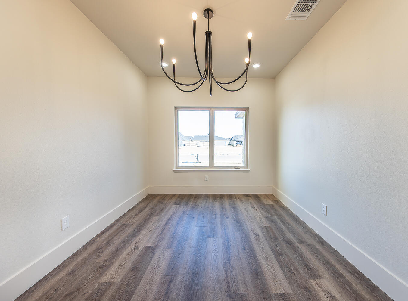 3605 143rd Street Lubbock, TX 79423 - Photo 12 of 34 an empty room with wooden floor mirror and windows