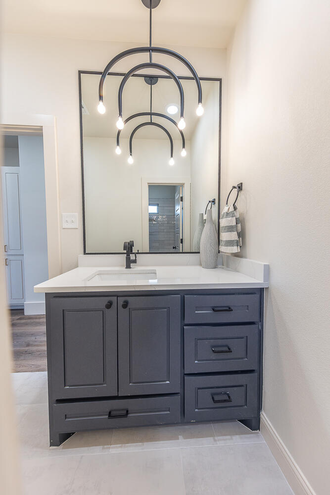 3605 143rd Street Lubbock, TX 79423 - Photo 19 of 34 a bathroom with a sink vanity and a mirror