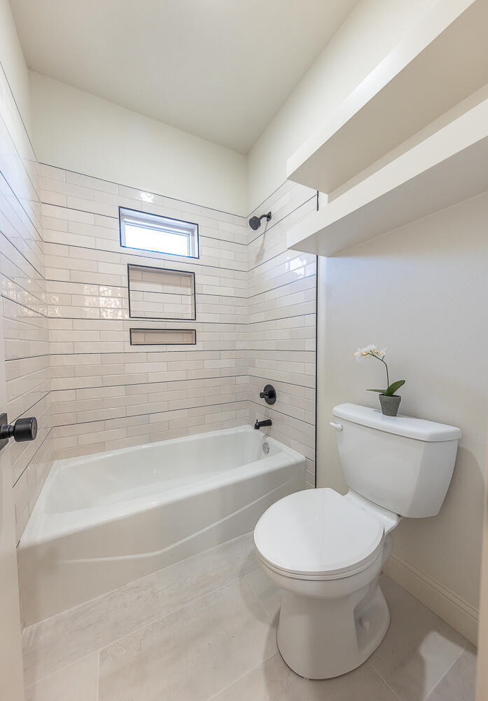 3605 143rd Street Lubbock, TX 79423 - Photo 20 of 34 a bathroom with a toilet a sink and bathtub