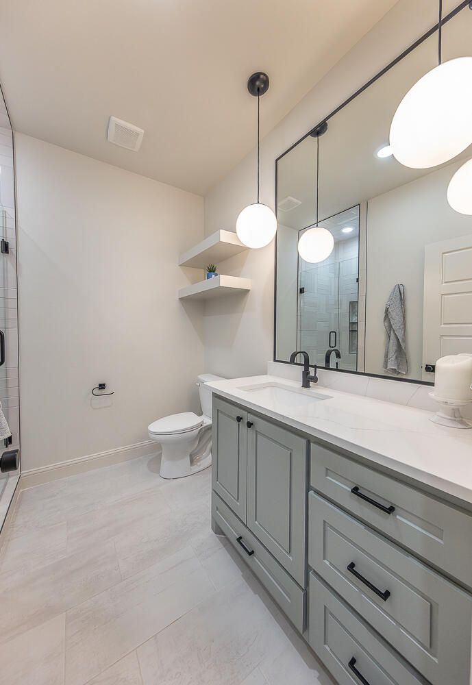3605 143rd Street Lubbock, TX 79423 - Photo 27 of 34 a bathroom with a double vanity sink toilet and a shower