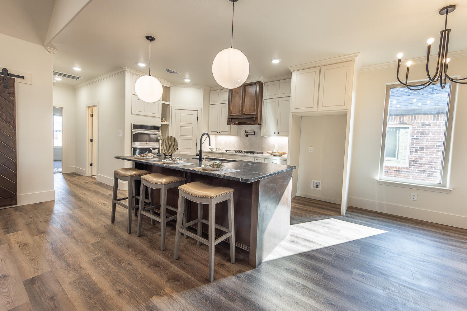 3605 143rd Street Lubbock, TX 79423 - Photo 9 of 34 a kitchen with stainless steel appliances granite countertop a stove a sink a oven a dining table and chairs with wooden floor
