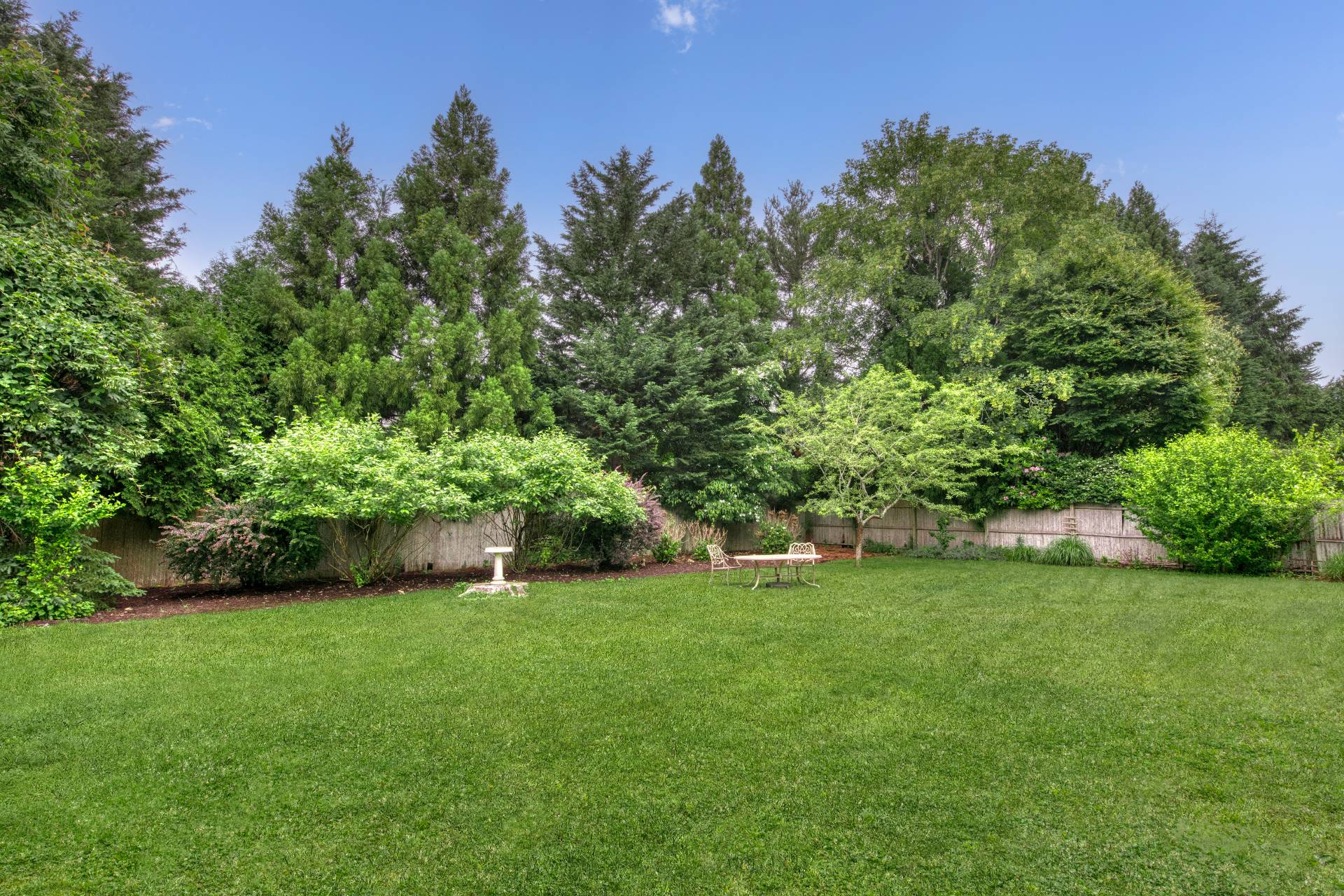 11 Maidstone Avenue East Hampton, NY 11937 - Photo 4 of 15 a view of a garden with a bench