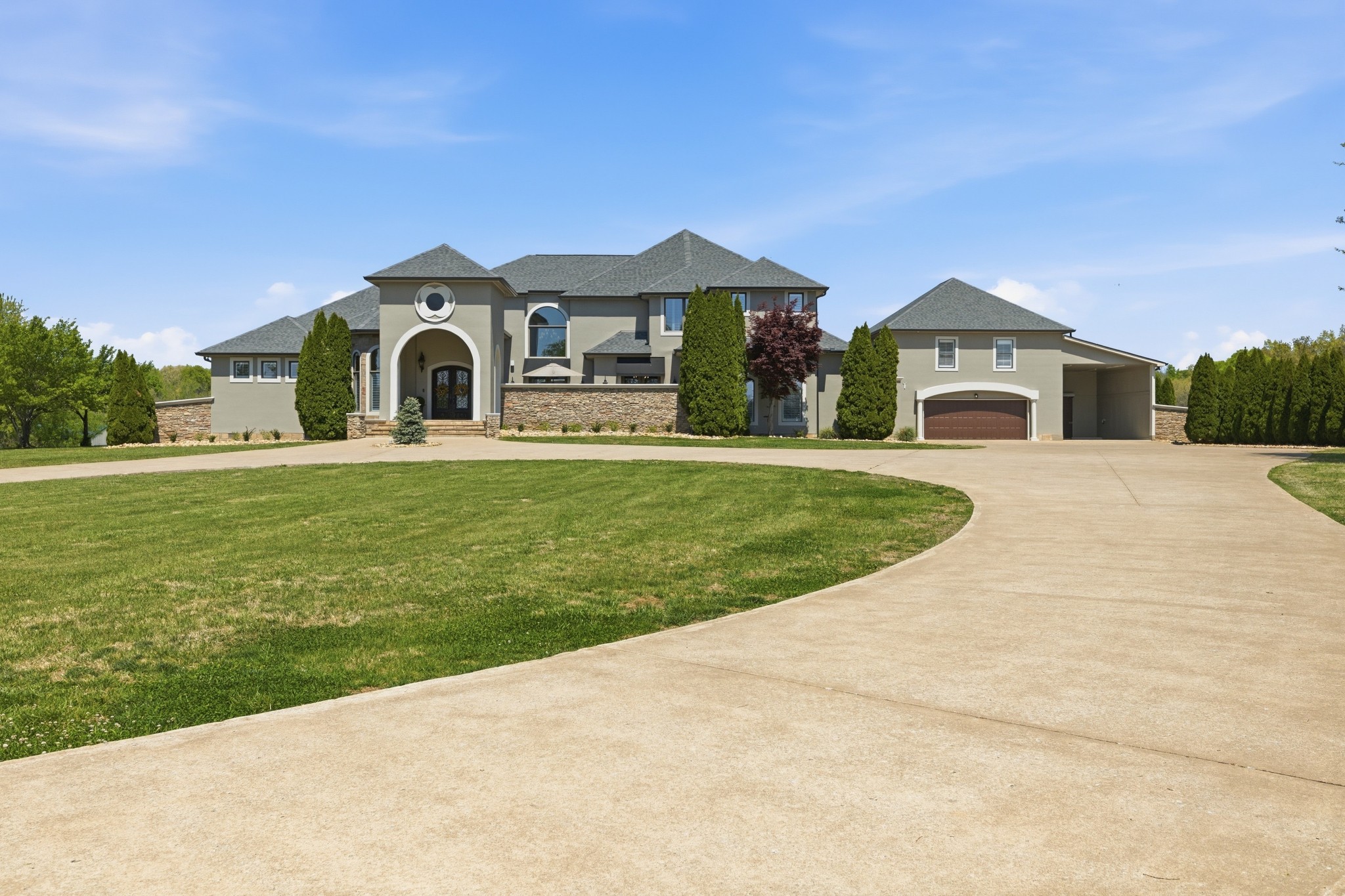 a front view of a house with a garden and yard