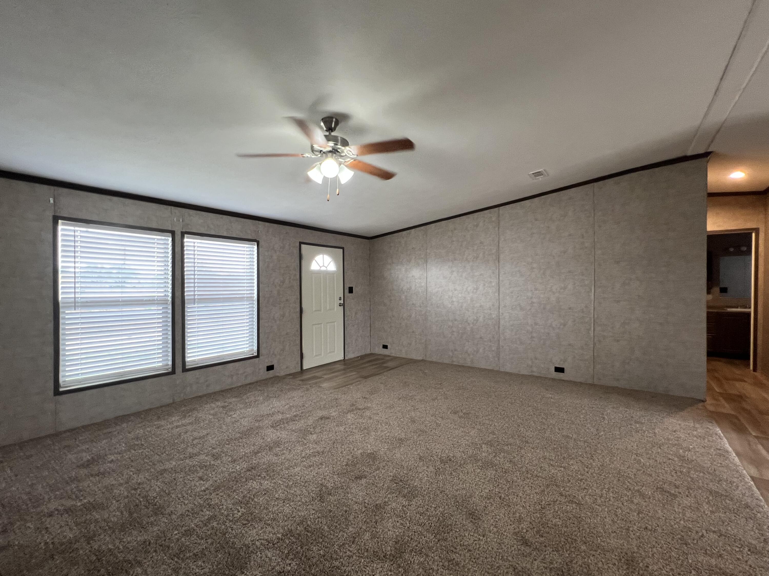 516 May Street Post, TX 79356 - Photo 12 of 31 an empty room with chandelier fan and windows