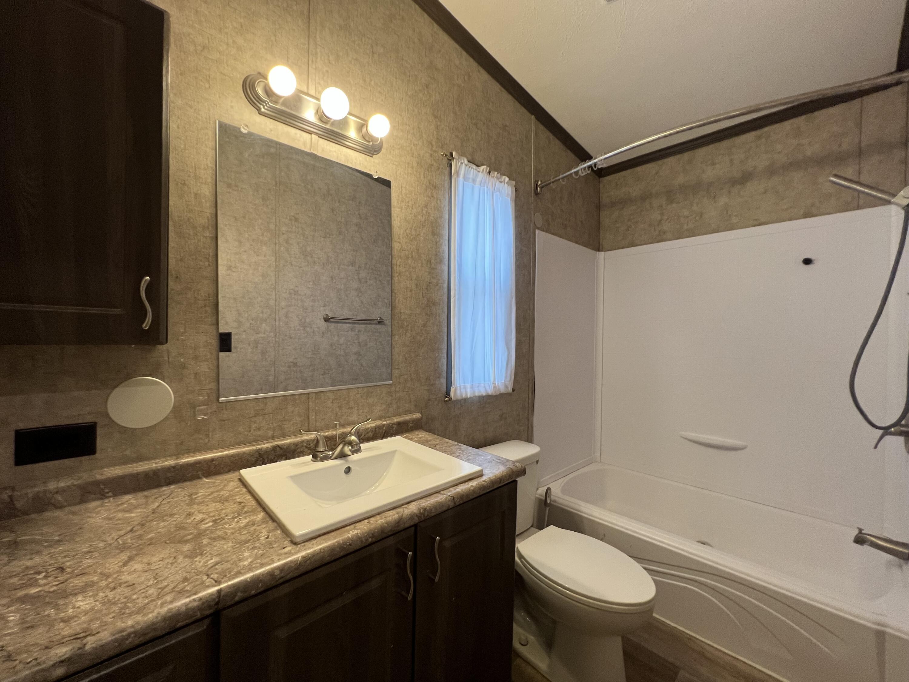 516 May Street Post, TX 79356 - Photo 24 of 31 a bathroom with a granite countertop sink toilet and shower