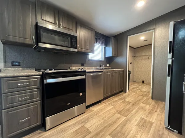 a kitchen with stainless steel appliances granite countertop a stove and a microwave
