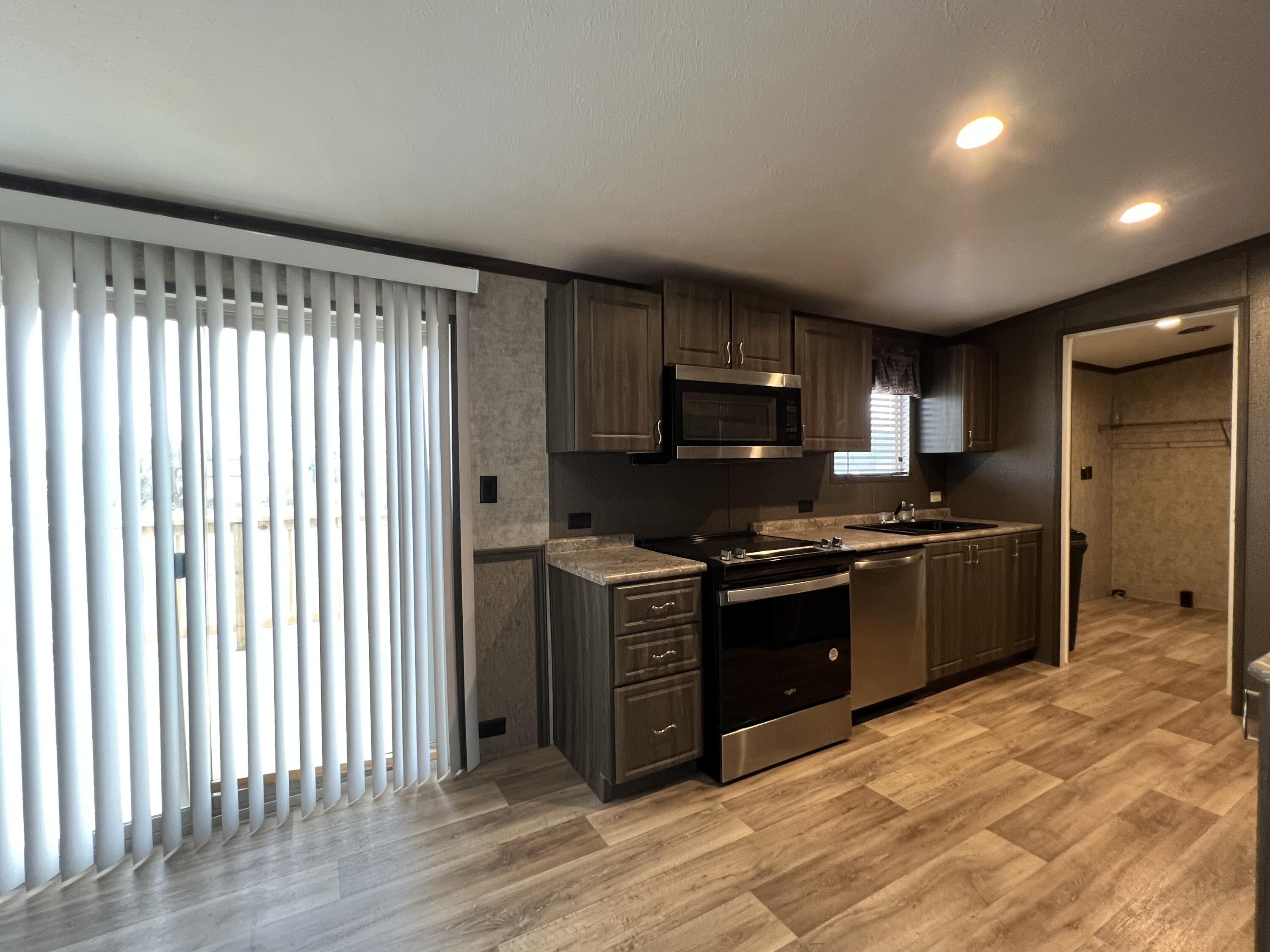 516 May Street Post, TX 79356 - Photo 4 of 31 a kitchen with stainless steel appliances granite countertop a stove a sink and a refrigerator