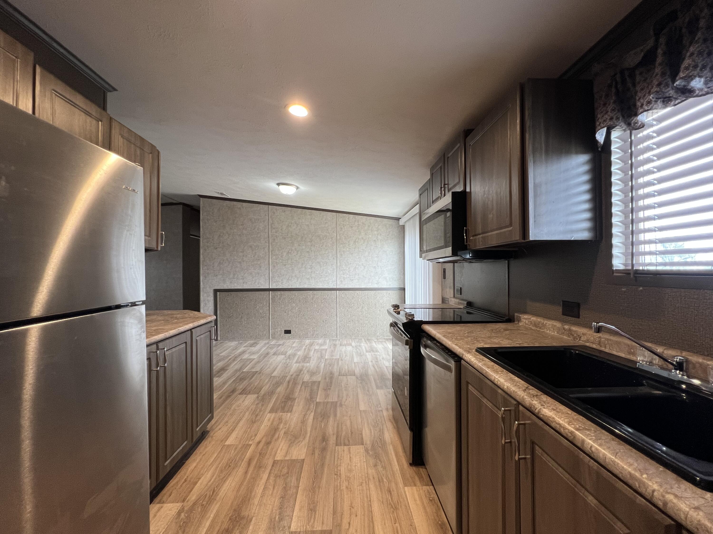 516 May Street Post, TX 79356 - Photo 6 of 31 a kitchen with a sink a refrigerator and cabinets
