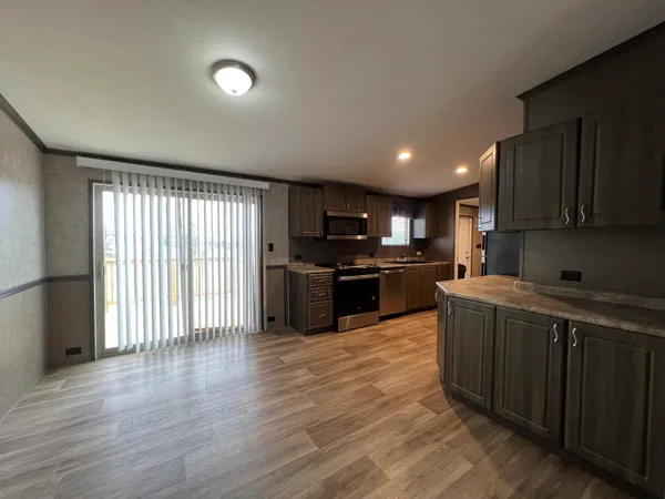 a kitchen with stainless steel appliances granite countertop a stove top oven a sink with wooden floors and cabinets