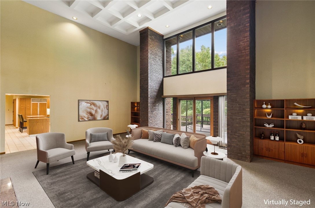 200 Hampshire Road Akron, OH 44313 - Photo 2 of 50 Expansive living area with a coffered ceiling, floor-to-ceiling windows, and a brick accent wall