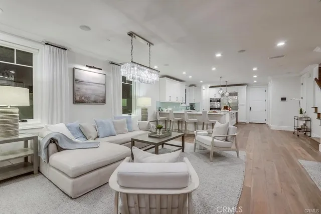 a living room with furniture kitchen and a wooden floor