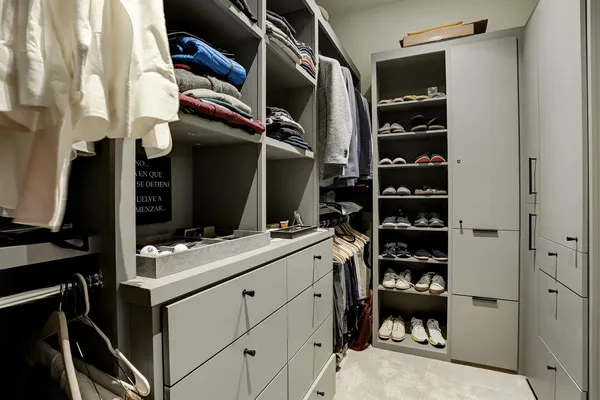 a view of walk in closet with clothes and shoes