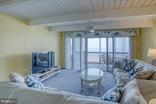 a living room with furniture a flat screen tv and a large window