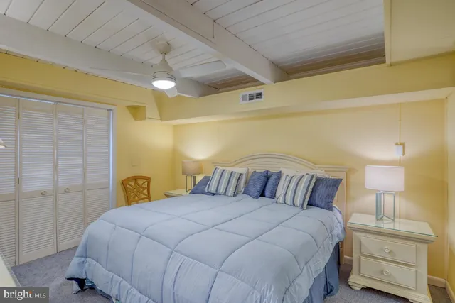 a bedroom with a bed and a lamp on dresser