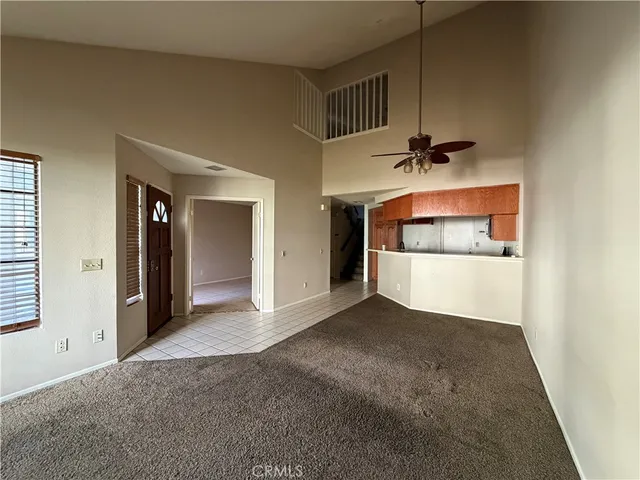 en empty room with a ceiling fan and window